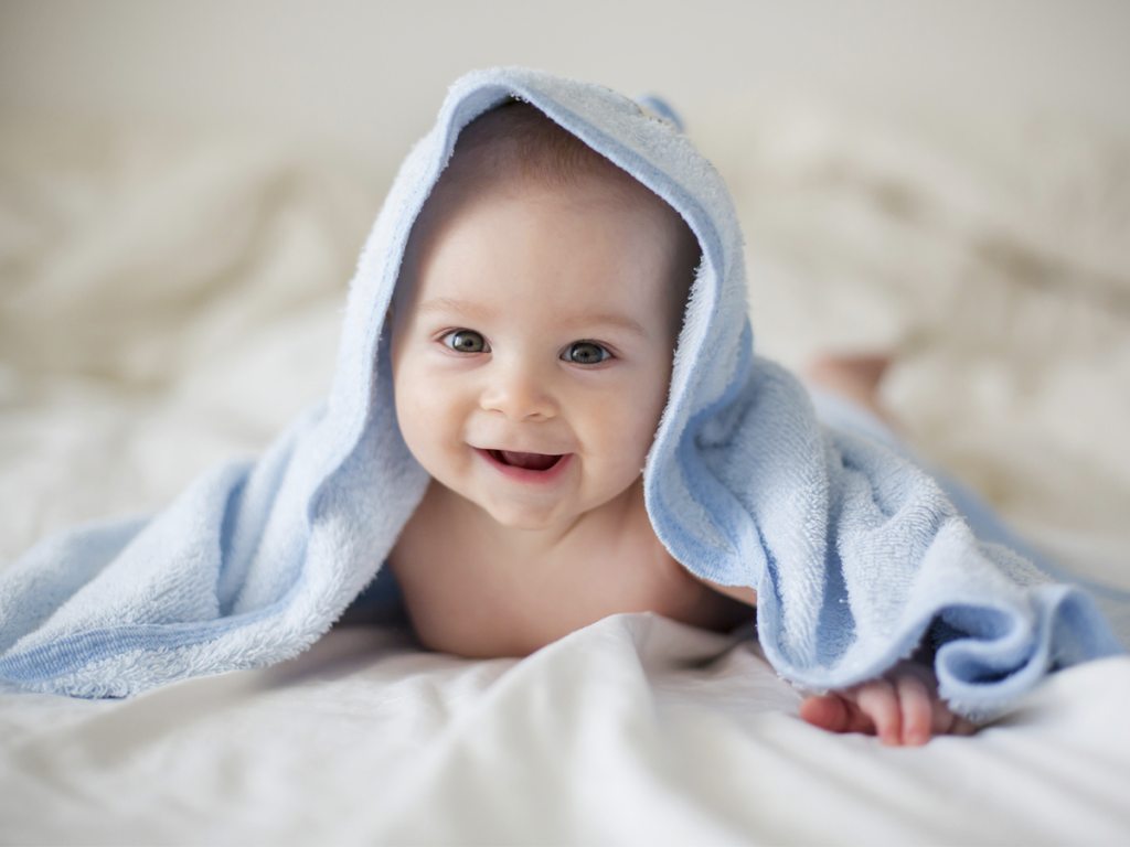 Bebé con cobija azul en la cabeza