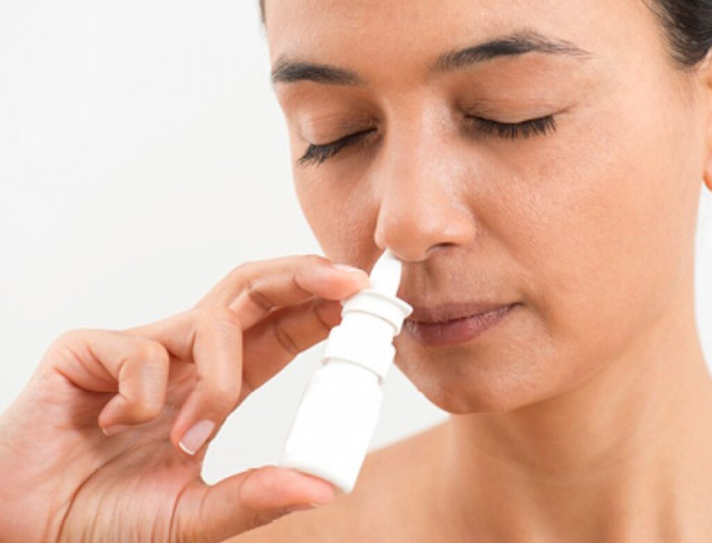 mujer usando descongestionante nasal